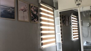 Ein modernes Badezimmer mit einem großen Spiegel, einer Dusche und einer Toilette.