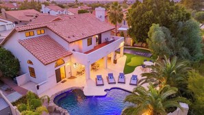 A two-story house with a swimming pool, outdoor seating, and a view of the surrounding neighborhood. - Golf Course+Heated Pool+Game Room+Putting Green (Mesa)