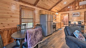 A cozy cabin interior with a dining area, kitchen, and seating space. - Cozy Broken Bow Cabin, Walk to the Lukfata Creek! (Broken Bow)