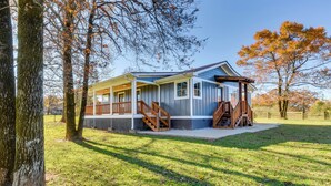 A two-story house with a porch and a covered staircase. - Modern Clarkesville Cottage w/ Decks & Patio! (Clarkesville)