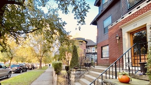 A residential building with a brick facade, a stone staircase with wrought iron railings, and a small pumpkin on the steps. - 2 Bed/1 Bath Apartment, Fully Stocked Kitchen, Spacious, Premium City Location (Buffalo)