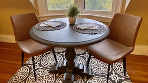 A round table with two chairs, a potted plant, and a patterned rug. - 2 Bed/1 Bath Apartment, Fully Stocked Kitchen, Spacious, Premium City Location (Buffalo)