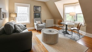 A cozy living room with a gray sofa, patterned armchair, and a round coffee table. - 2 Bed/1 Bath Apartment, Fully Stocked Kitchen, Spacious, Premium City Location (Buffalo)
