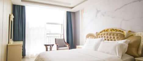 Habitación de hotel con una cama grande, una silla, una mesita de noche y vistas al exterior.