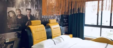 A hotel room with a bed, a nightstand, and a poster on the wall.