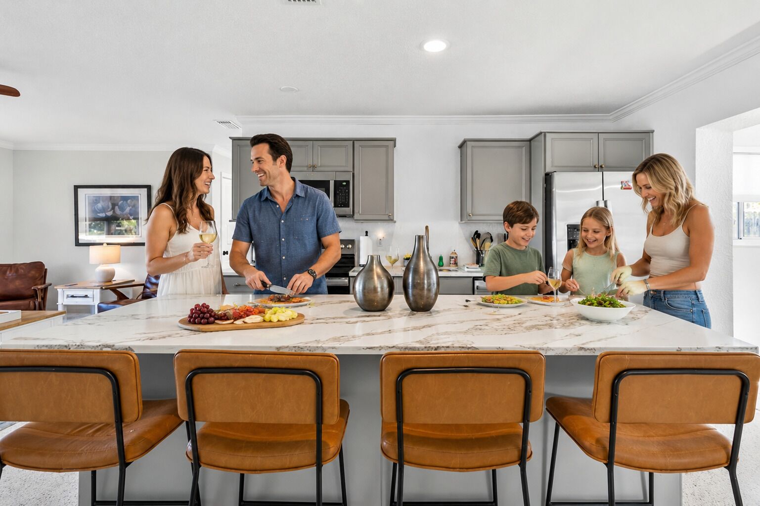 A modern kitchen with a central island, grey cabinets, and a marble countertop.