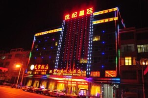 Un hôtel à plusieurs étages, doté d’une enseigne lumineuse et d’une entrée imposante.