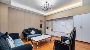 Ein geräumiges Wohnzimmer mit einer Sofagarnitur, einem Couchtisch und einer Kronleuchter.