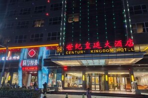 Un hôtel avec une grande enseigne indiquant « CENTURY KINGDOM HOTEL » et une plus petite enseigne indiquant « SHANGHAI CENTURY KINGDOM HOTEL ».