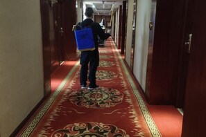 Ein Hotelgang mit rotem Teppich und Holztüren.