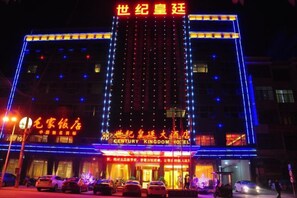 Ein Hotel mit auffälliger Beschilderung, mehreren Etagen und beleuchteter Fassade.