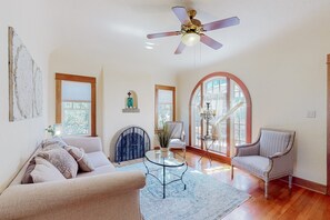Ein geräumiges Wohnzimmer mit einer Couch, einem Sessel und einem Glastisch.