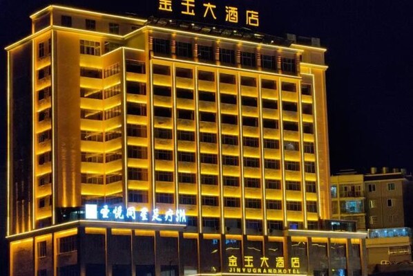 A multi-story hotel with illuminated signage and a modern architectural design.