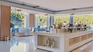 Un moderno vestíbulo de hotel con mostrador de recepción, zona de estar y amplias ventanas con vistas al exterior.