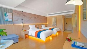 Una habitación de hotel moderna con cama, mesitas de noche, escritorio y una silla.