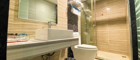 Une salle de bain moderne avec une douche à parois de verre, un lavabo blanc et un miroir au-dessus.