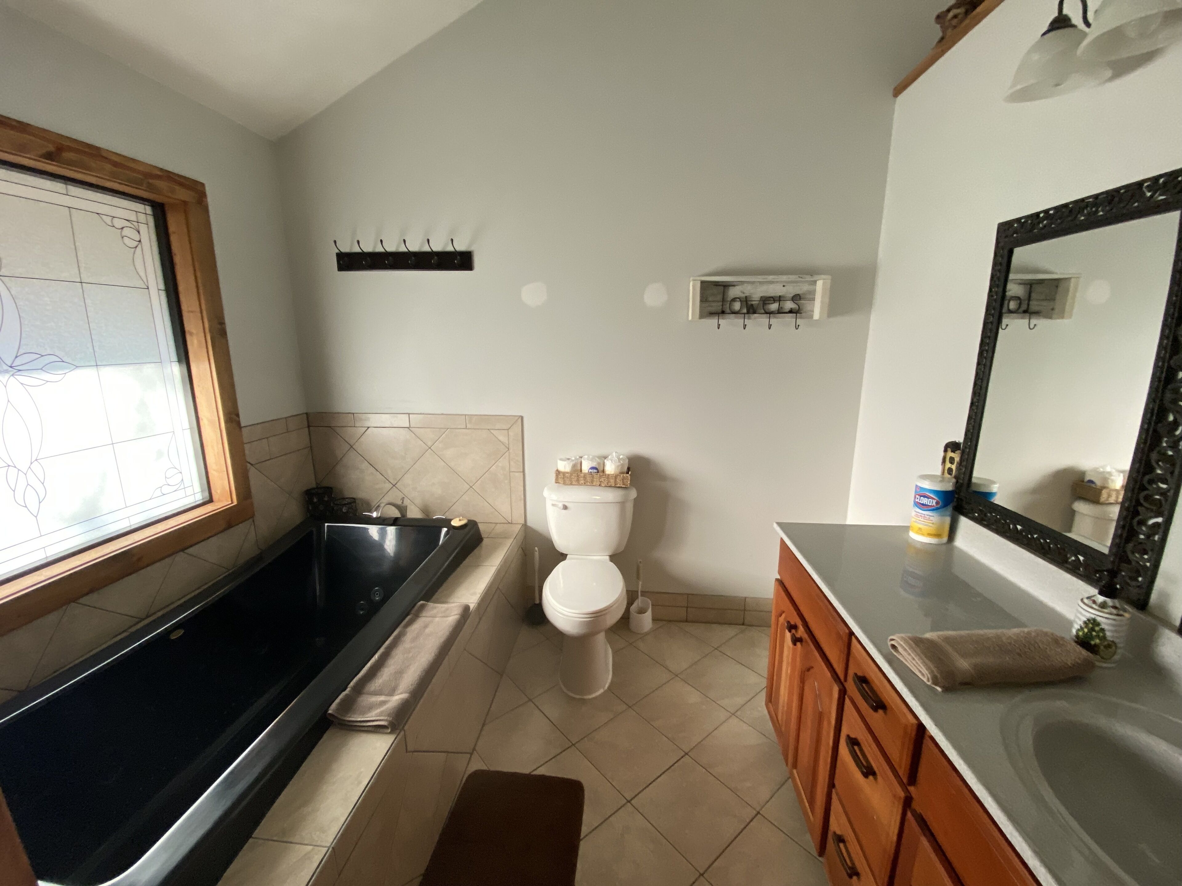 Une salle de bain équipée d’une baignoire, de toilettes, d’un meuble-lavabo et d’un grand miroir.