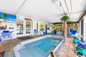 Relax by the pool in a tranquil oasis with lounge chairs and a small table.