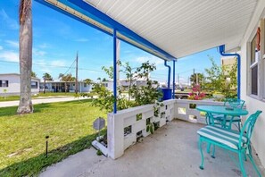 Relax under the shade of a palm tree in this serene outdoor space, surrounded by lush greenery and a beautiful view.