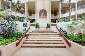 Step into a lush oasis with a central staircase and beautiful tropical plants.