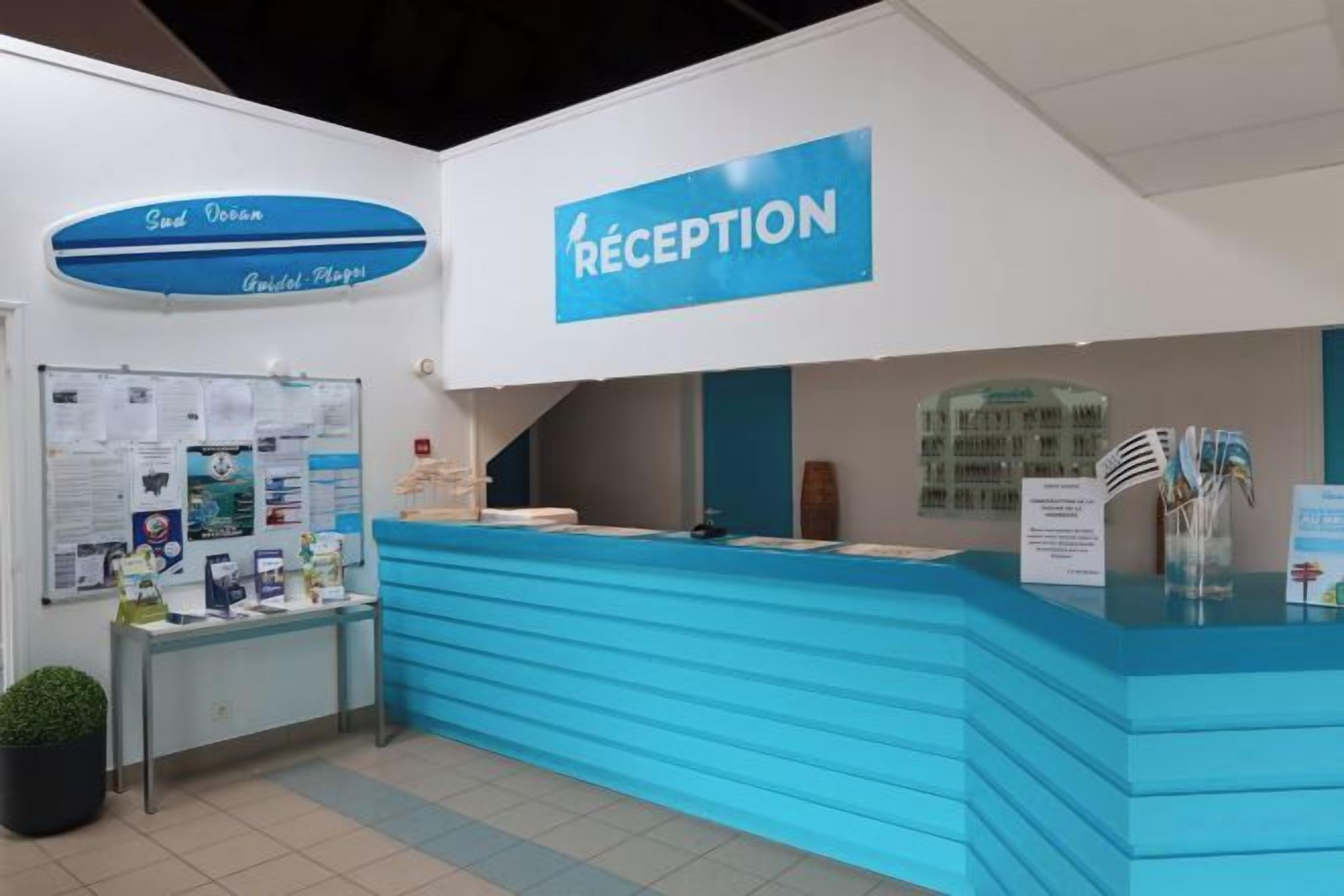 A reception desk with a blue counter and a sign that reads 'RECEPTION'.