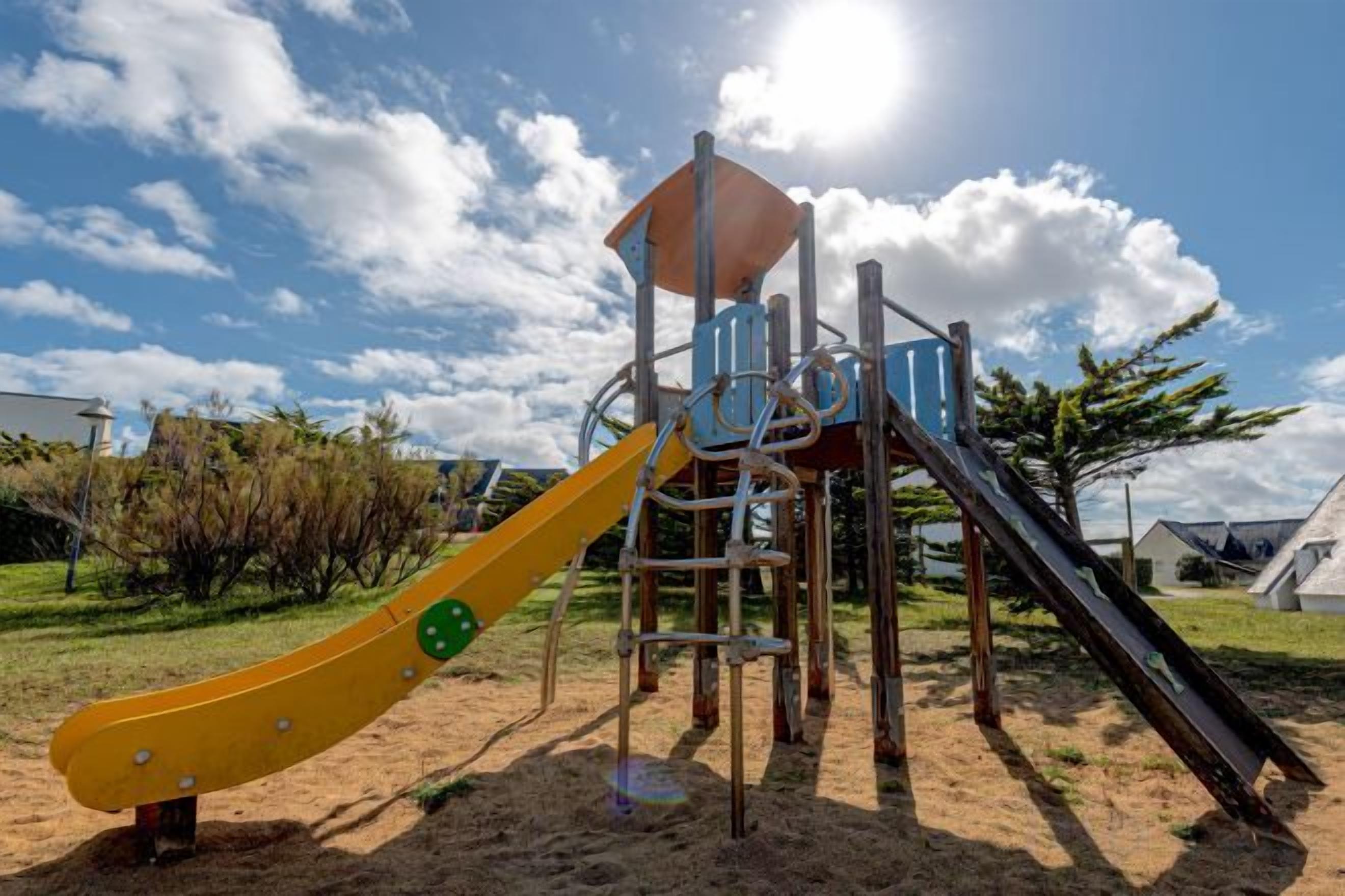 A playground with a slide and climbing structures.
