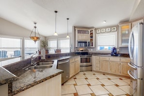 Enjoy cooking in this well-equipped kitchen with a central island, sink, and stainless steel appliances.