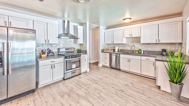 A modern kitchen with stainless steel appliances, white cabinetry, and a wooden floor. - VIP villa 3BDR 2BHR 5min to the strip large pool (Las Vegas)