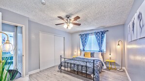 A bedroom with a bed, ceiling fan, bedside lamps, and a window with patterned curtains. - VIP villa 3BDR 2BHR 5min to the strip large pool (Las Vegas)