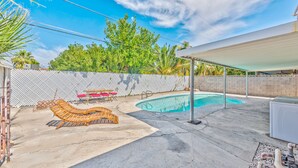 A backyard with a swimming pool, lounge chairs, and a covered patio area. - VIP villa 3BDR 2BHR 5min to the strip large pool (Las Vegas)