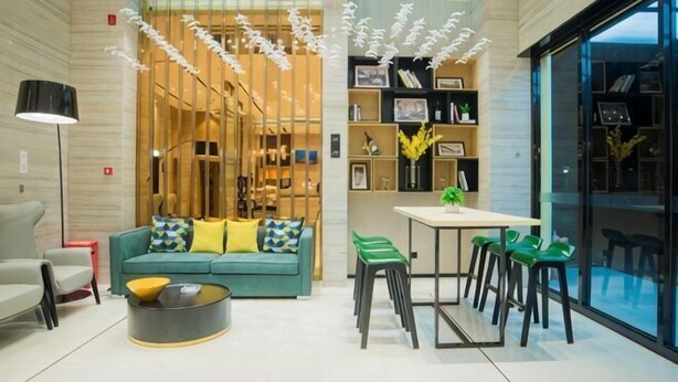 Un intérieur moderne comprenant un canapé, une table à manger, des chaises, une lampe et une bibliothèque.