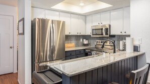 A modern kitchen with a central island, stainless steel appliances, and a skylight. - 3 BR, 3 Bath sleeps 10.  Next to Giant Steps Lodge.  Ski in/out (Brian Head)