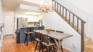 A modern kitchen with a central island, wooden dining table, and chairs. - 3 BR, 3 Bath sleeps 10.  Next to Giant Steps Lodge.  Ski in/out (Brian Head)