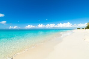 In Strandnähe, weißer Sandstrand, Liegestühle, Sonnenschirme