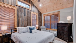 A bedroom with a large bed, wooden walls, and multiple windows with blinds. - Banner Bear - 1 mile from downtown Banner Elk, Skiing, restaurants (Banner Elk)