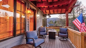 A wooden deck with outdoor seating, a flag, and a view of the mountains. - Banner Bear - 1 mile from downtown Banner Elk, Skiing, restaurants (Banner Elk)