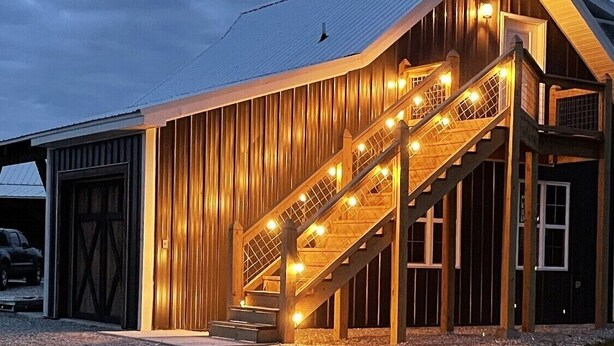 A large barn-like building with a wooden exterior and a staircase leading to a second level. - COUNTRY LACE Retro Place (Cabool)