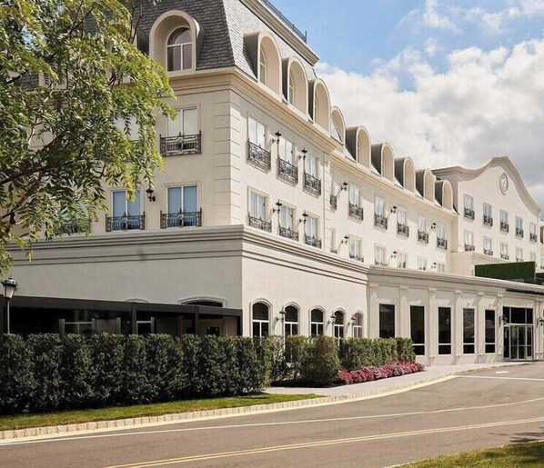 A multi-story hotel with a symmetrical facade, large windows, and a central entrance.