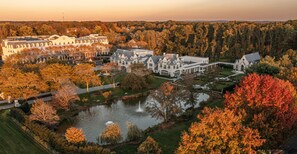 A large estate with multiple buildings, a pond, and a fountain.