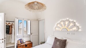 A bedroom with a bed, a hanging light fixture, a wardrobe, and a small wooden chest. - Mare Mare Mare (Gallipoli)
