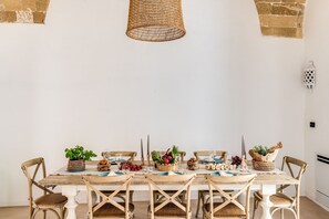 A dining table set with chairs, a woven light fixture, and decorative items. - Palazzo Santa Caterina -una Volta (Gallipoli)