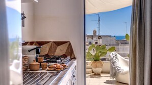 A balcony with a grill, a potted plant, and a view of the sea. - Il Nido Gallipoli (Gallipoli)