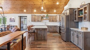 Una cocina moderna con armarios de madera, una isla central y una zona de comedor con banco.