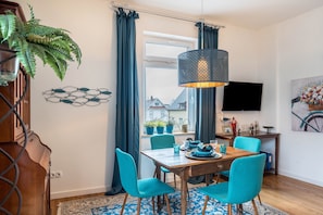 Un espace repas comprenant une table, des chaises et un luminaire suspendu.