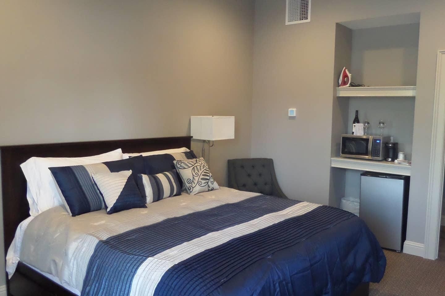 Une chambre d’hôtel avec un lit, un bureau doté d’un micro-ondes et une chaise.