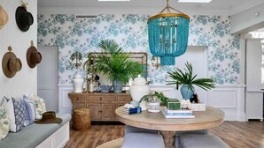 A room with a round table, a hanging chandelier, and a wall with hats. - Hamptons Farm Estate—Luxe Retreat & Elegant Events (Wongamine)