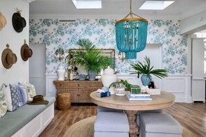 A room with a round table, a hanging chandelier, and a wall with hats. - Hamptons Farm Estate—Luxe Retreat & Elegant Events (Wongamine)