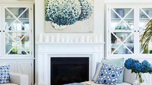 A living room with a fireplace, two sofas, a large floral artwork, and a patterned rug. - Hamptons Farm Estate—Luxe Retreat & Elegant Events (Wongamine)