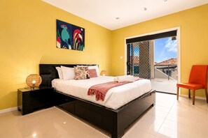 A modern bedroom with a bed, a nightstand, a lamp, a chair, and a balcony with a view. - "The View" Luxury home 5 bed/3 bath 3km to Casino. (Sandy Bay)