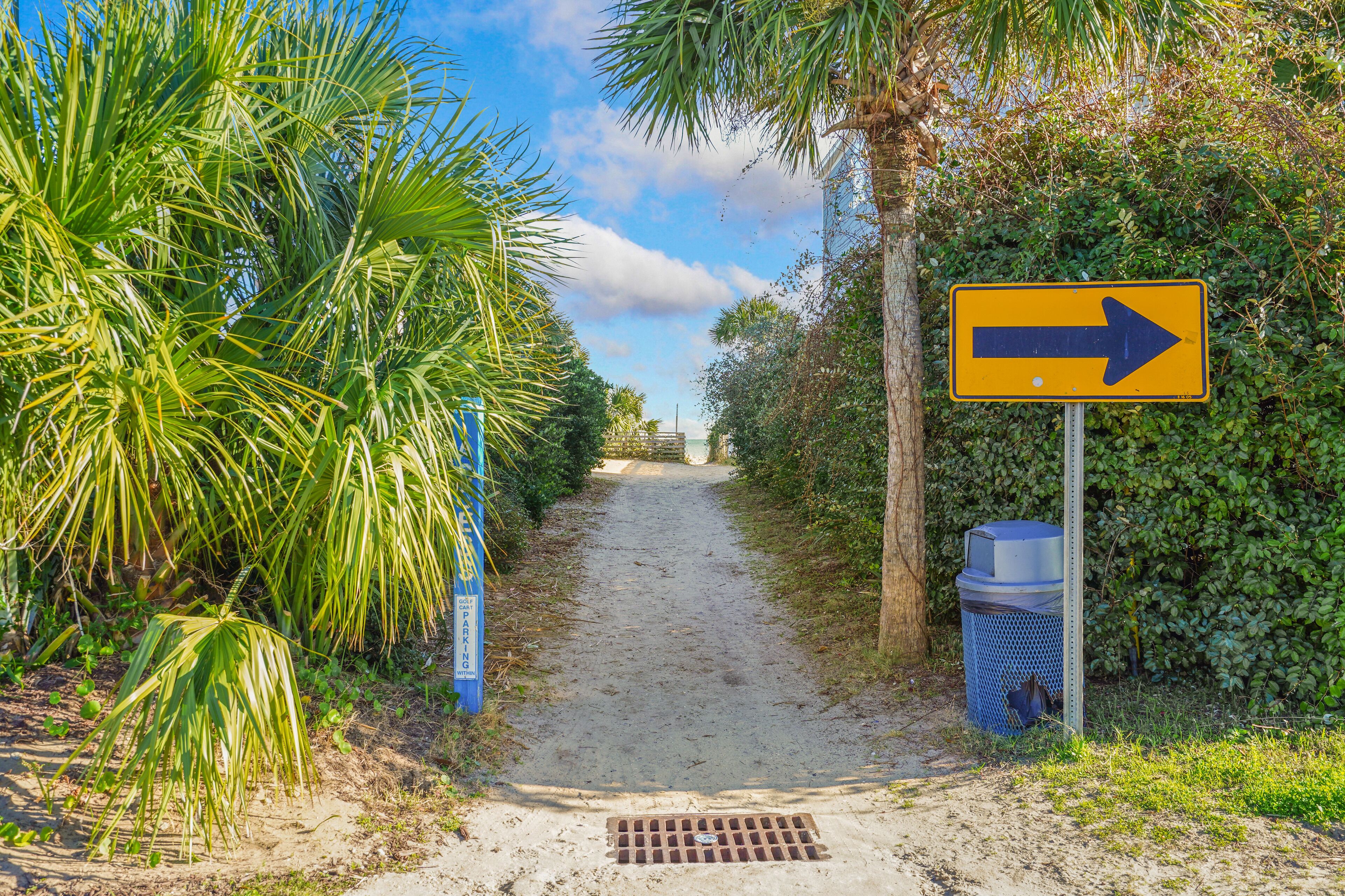 A pathway leading to a building with a directional sign.
